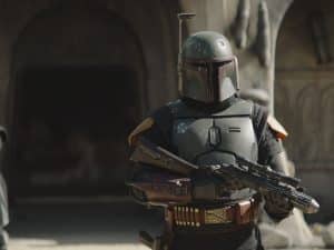 Boba Fett carries and assault rifle to shoot stormtroopers